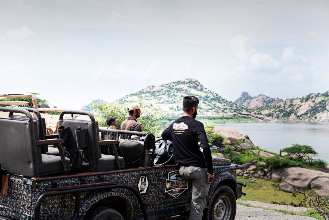Local safari driver standing beside a Jawai jeep